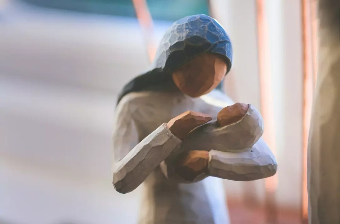A photo shows a figurine of a mother cradling a child.