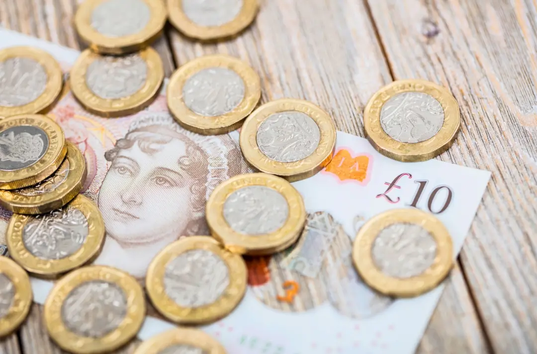 A photo shows a £10 note covered in £1 coins.