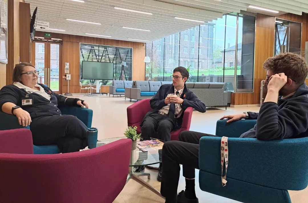 A photo shows three cadets having a conversation in the hub at William Booth College.