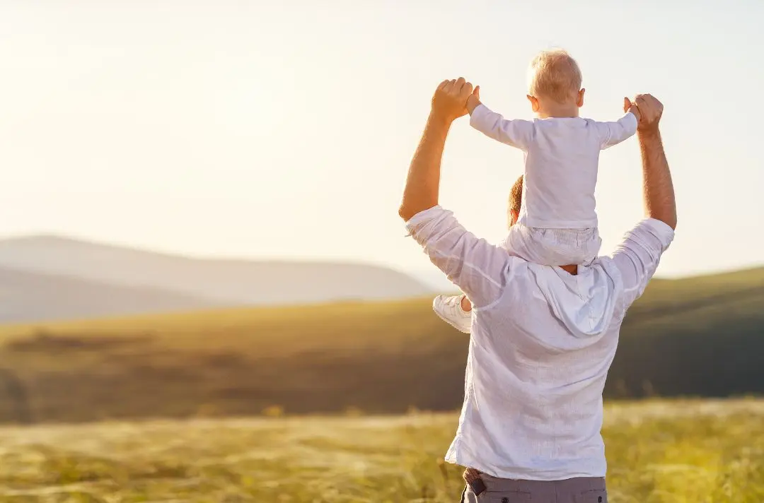 A photo of a man with his child on his shoulders