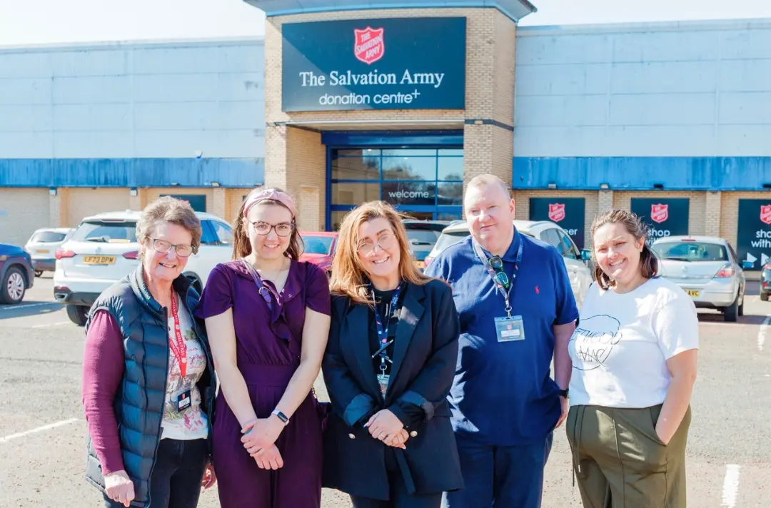 A photo shows five people posing outside the Renfrew SATCoL Donation Centre.