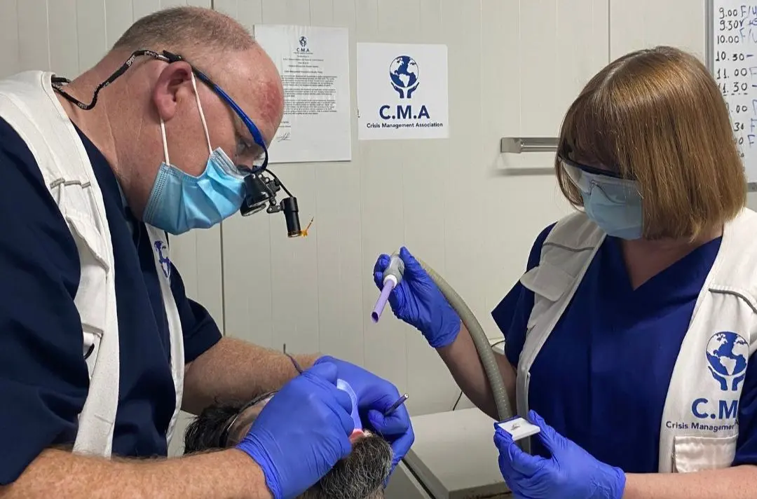A photo of Robert and his wife performing dental surgery