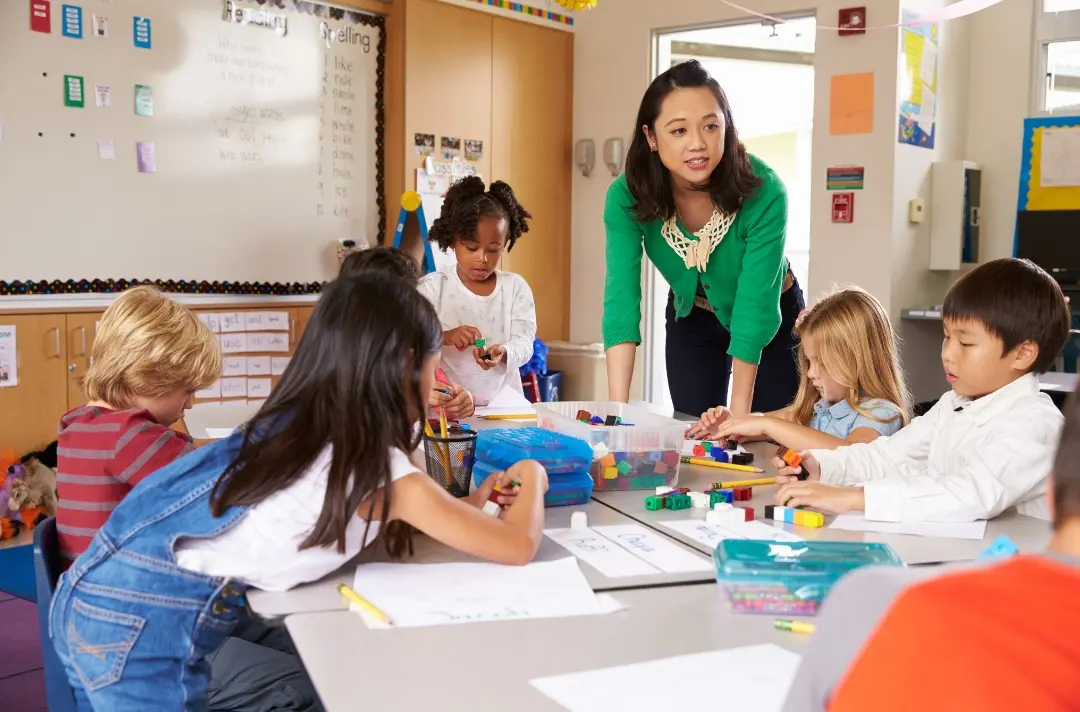 A photo shows someone teaching a class of young children.