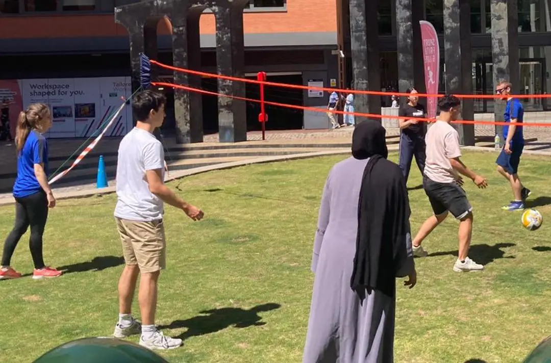 A diverse group of people playing volleyball outside