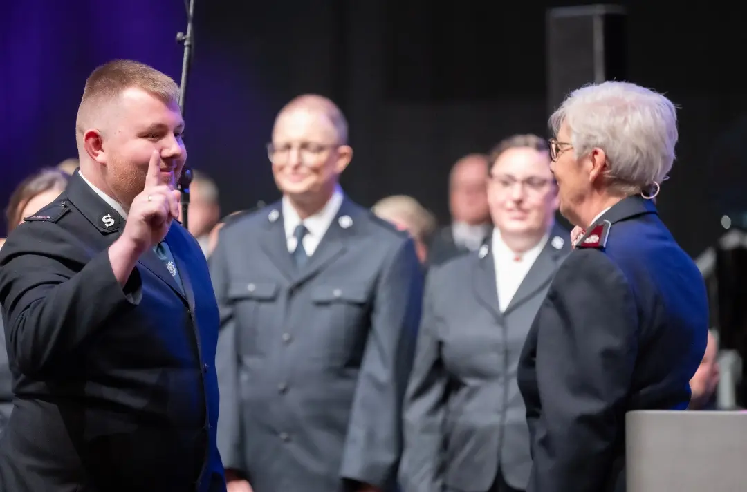 A photo shows a cadet saluting Commissioner Jenine Main during the ordination and commissioning ceremony.