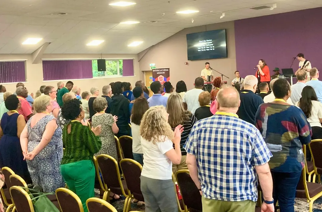 A photo shows people worshipping at the Intercultural Mission Conference 2025.
