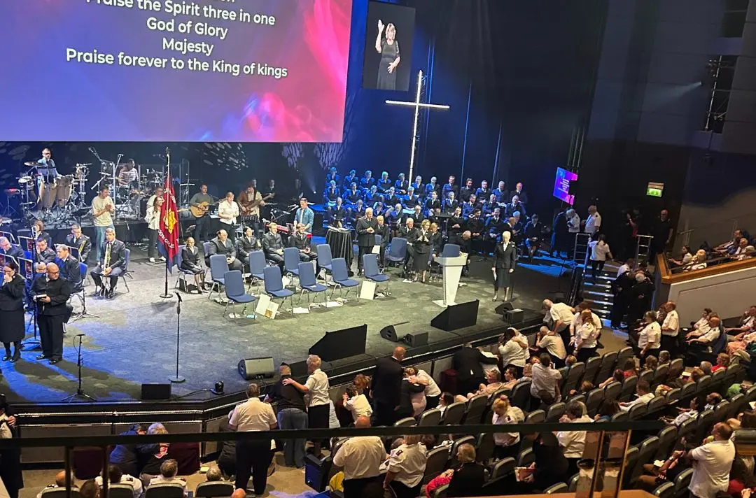 People come to the stage to kneel and pray with one another at Together 2025