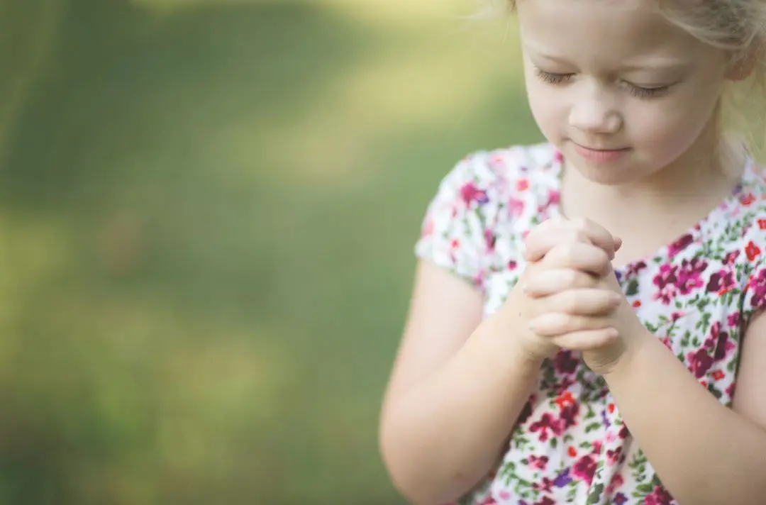 A little girl prays.