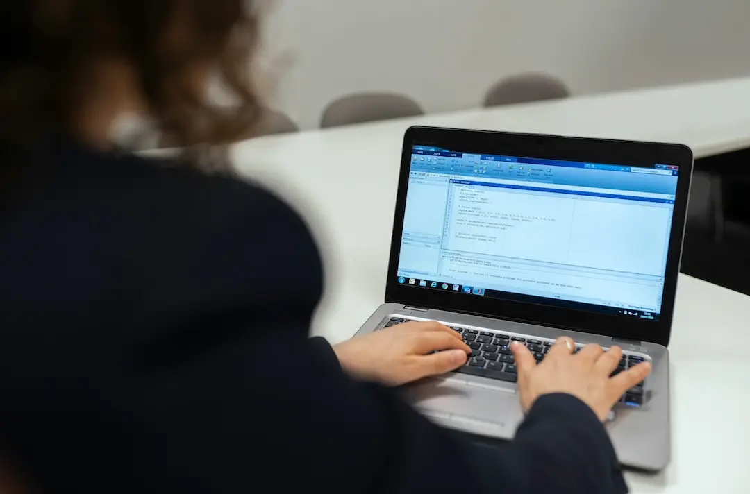 A woman uses a laptop at a desk