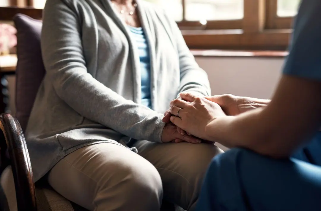 Someone supporting a woman and holding her hands