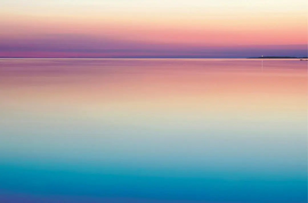 A sunset over calm, peaceful water.