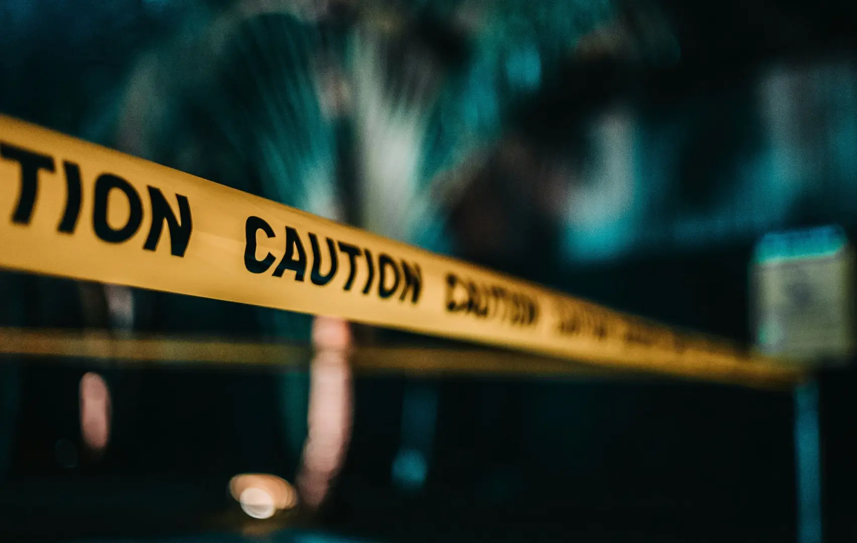 Police cordon tape with 'caution' written on it.