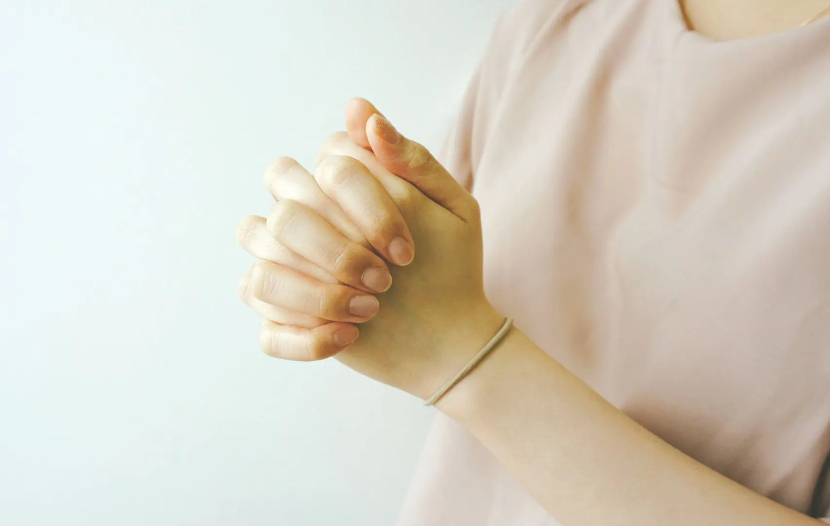 A girl praying with her hands clasped.