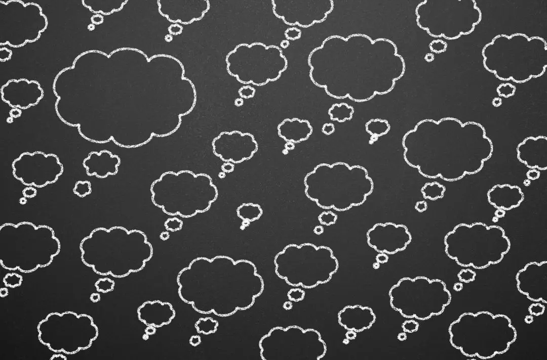 A black background with thought bubbles in white chalk