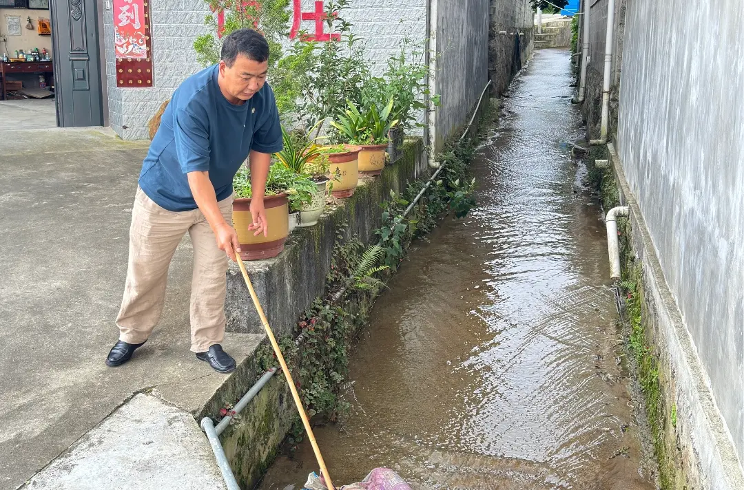 A photo shows Mr Guo clearing the drainage system in front of his restaurant.