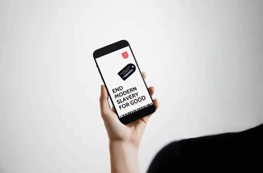 A photo shows a phone displaying a graphic that reads: End modern slavery for good.