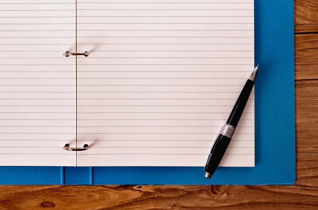 A photo shows a notepad and pen.