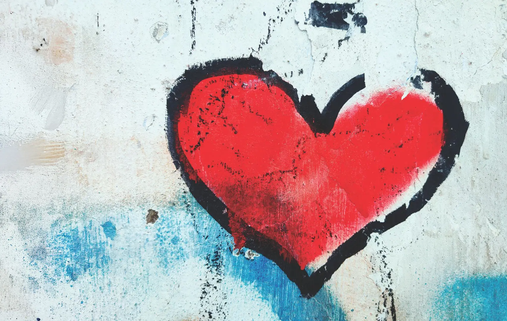 A red heart graffitied onto a white wall.