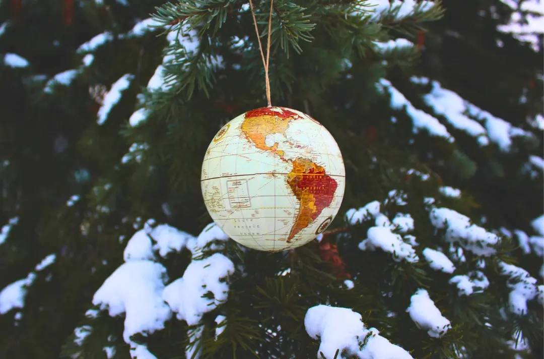 A photo shows a bauble that looks like a globe hanging from a tree.