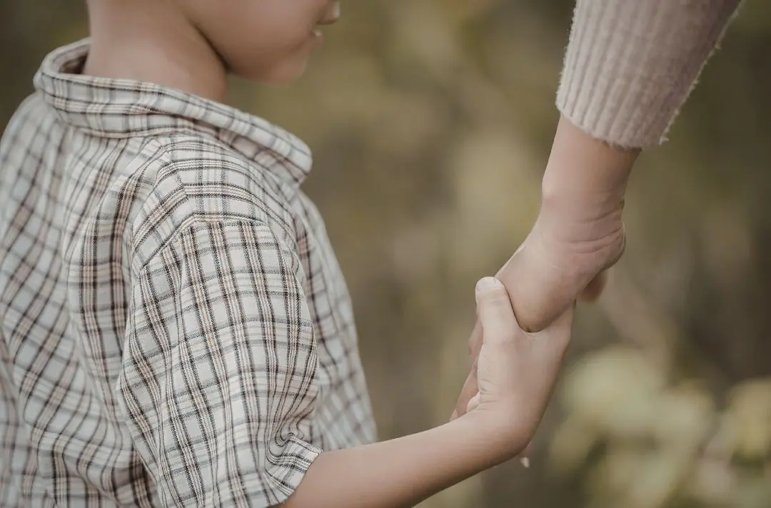 Mother holding her son's hand
