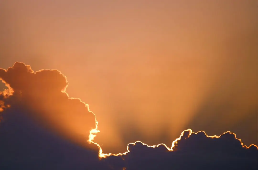 The sun breaking through a dark patch of clouds.