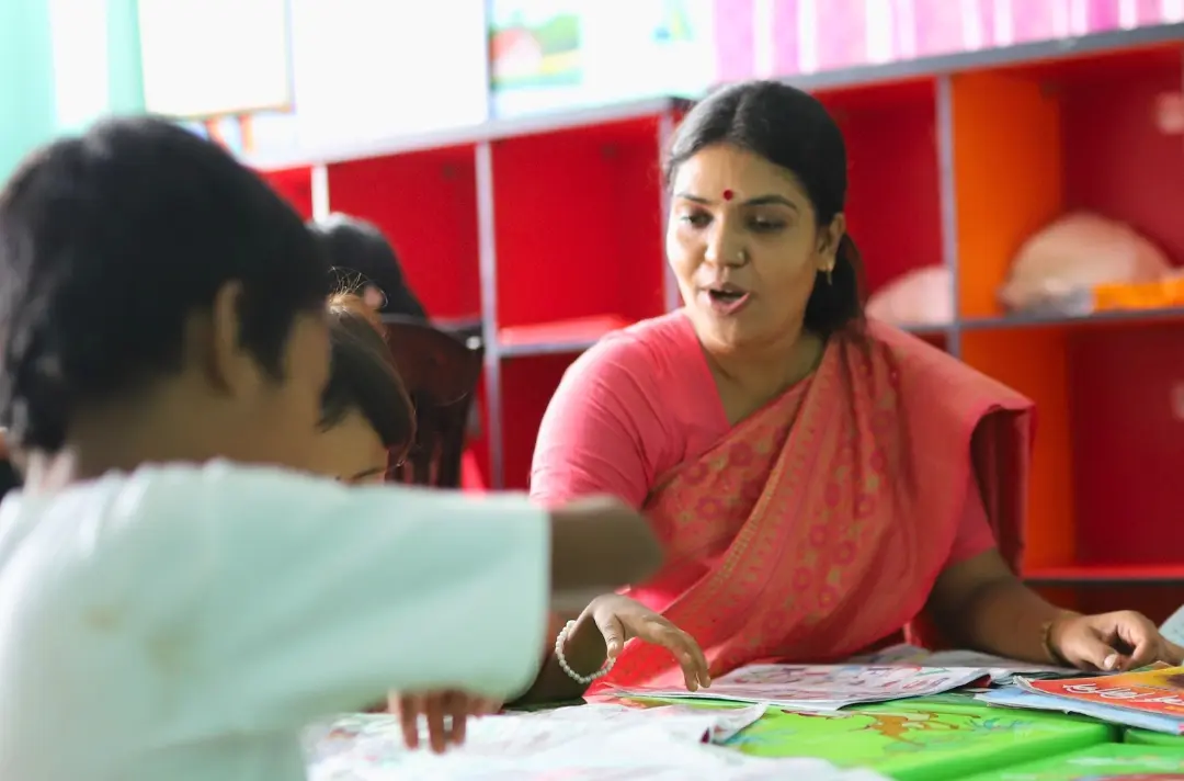 A photo shows Barna teaching at a school.