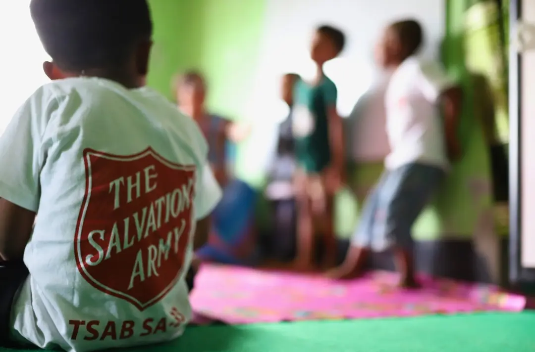 A photo shows children gathered around.