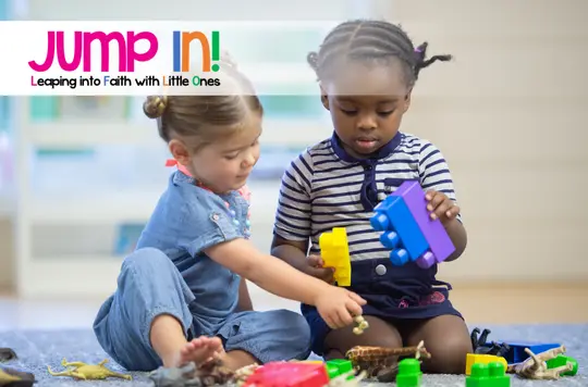 two young girls playing building block toys together