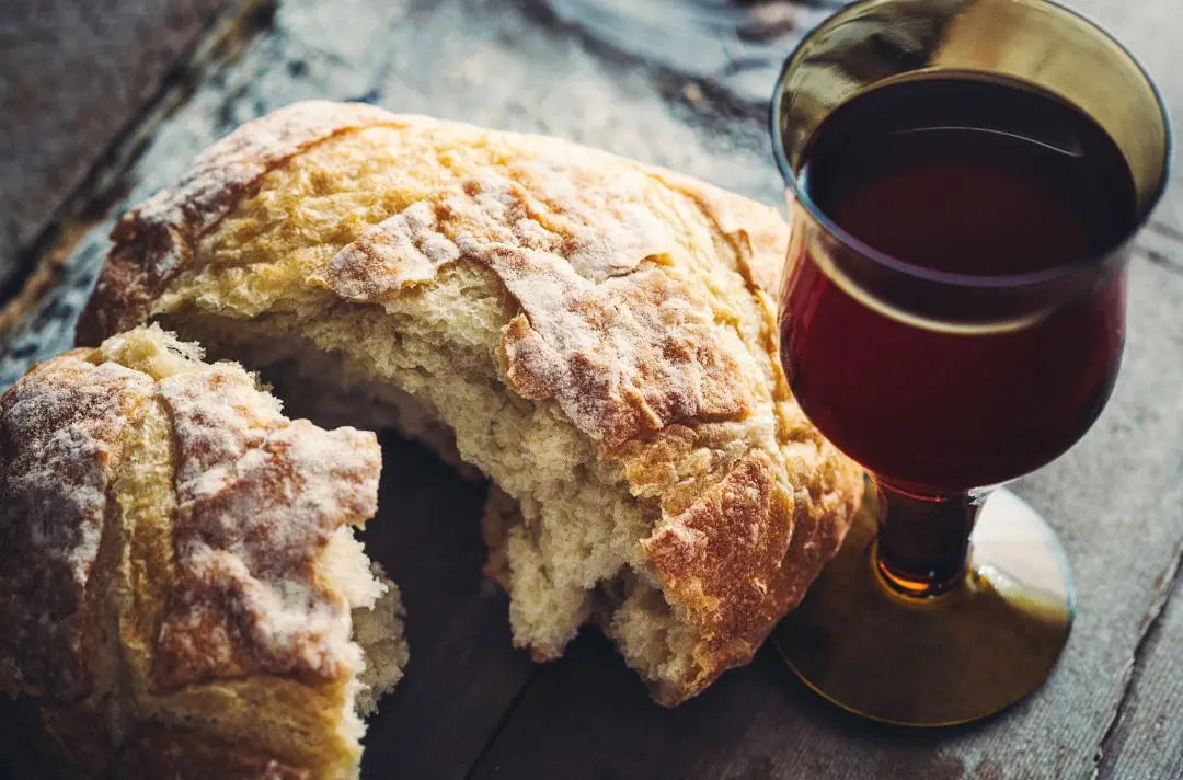 A photo of a loaf of bread and a glass of wine