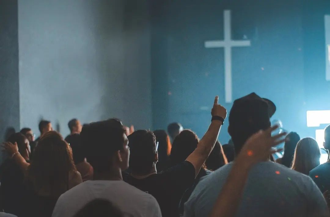 A crowd of young people standing up in worship