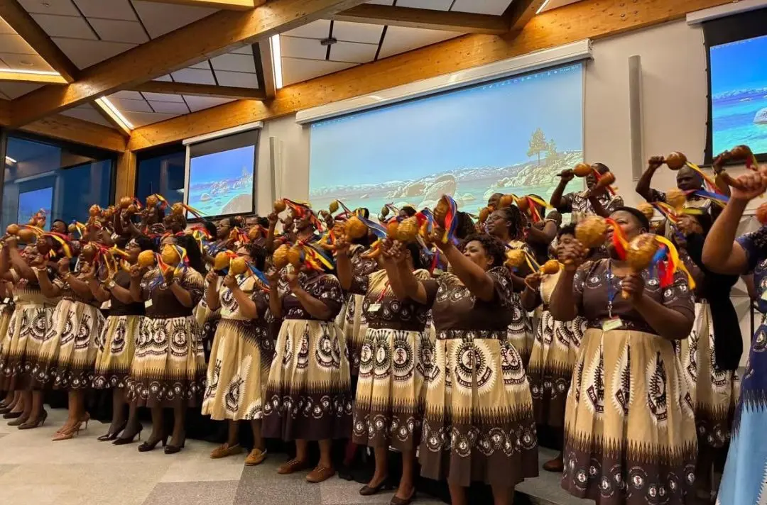 Members of African Praise in their traditional dress dance with colourful ribbons.
