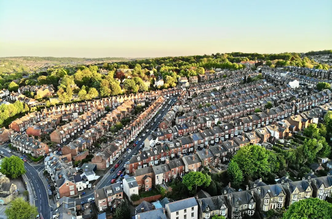 An aerial photo of a city with residential buildings and green treets