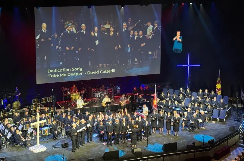 Keepers of the Covenant singing their dedication song 'Take Me Deeper' by David Cotterill, supported by members of the International Staff Songsters