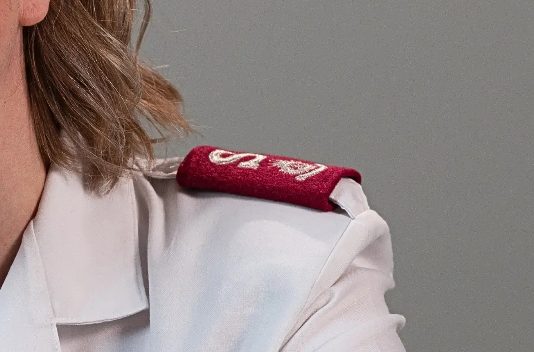 A photo shows an officer's uniform with a major rank epaulette.