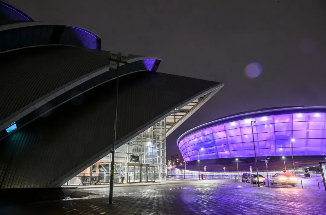 A photo of the Ovo Hydro Arena at night, lit up by floodlights. Picture taken by Craig Watson.