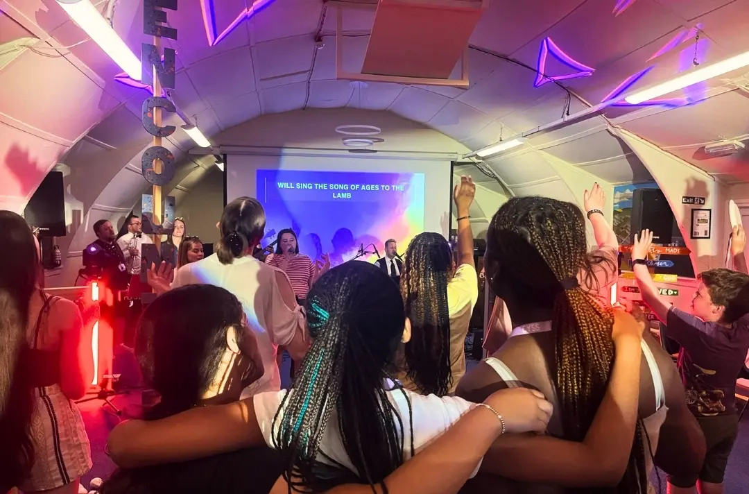A photo shows worship at the East of England summer school.