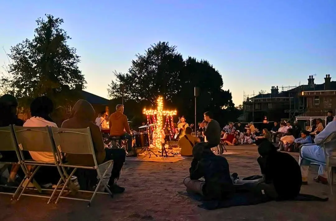 A photo shows people gathered around a cross made of lights at London and South East.