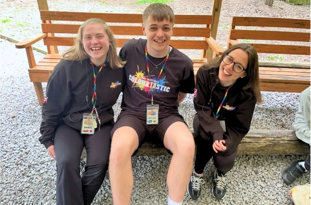 A photo shows three people smiling at the North West junior camp.
