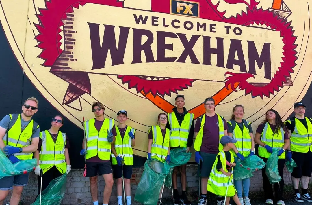 A photo shows people out litter picking at the Wales and East Midlands summer school.