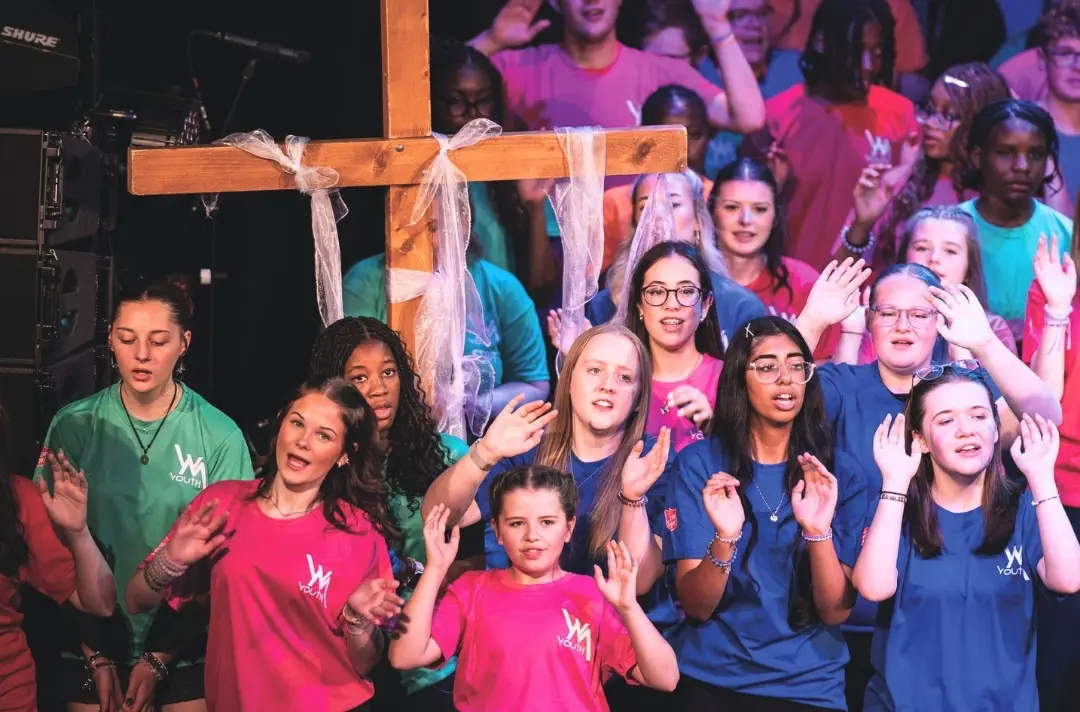 A photo shows people singing and dancing at the West Midlands summer school.