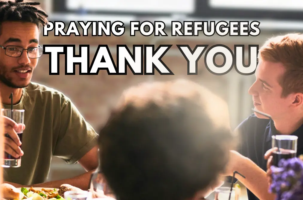 a photo of a group of people around a table, enjoying a meal, with the words 'praying for refugees thank you'